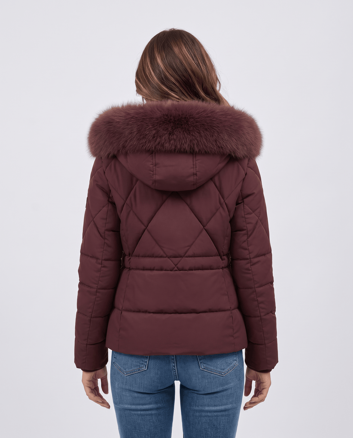 Back of maroon quilted jacket showing diamond panels and plush hood trim on model in jeans