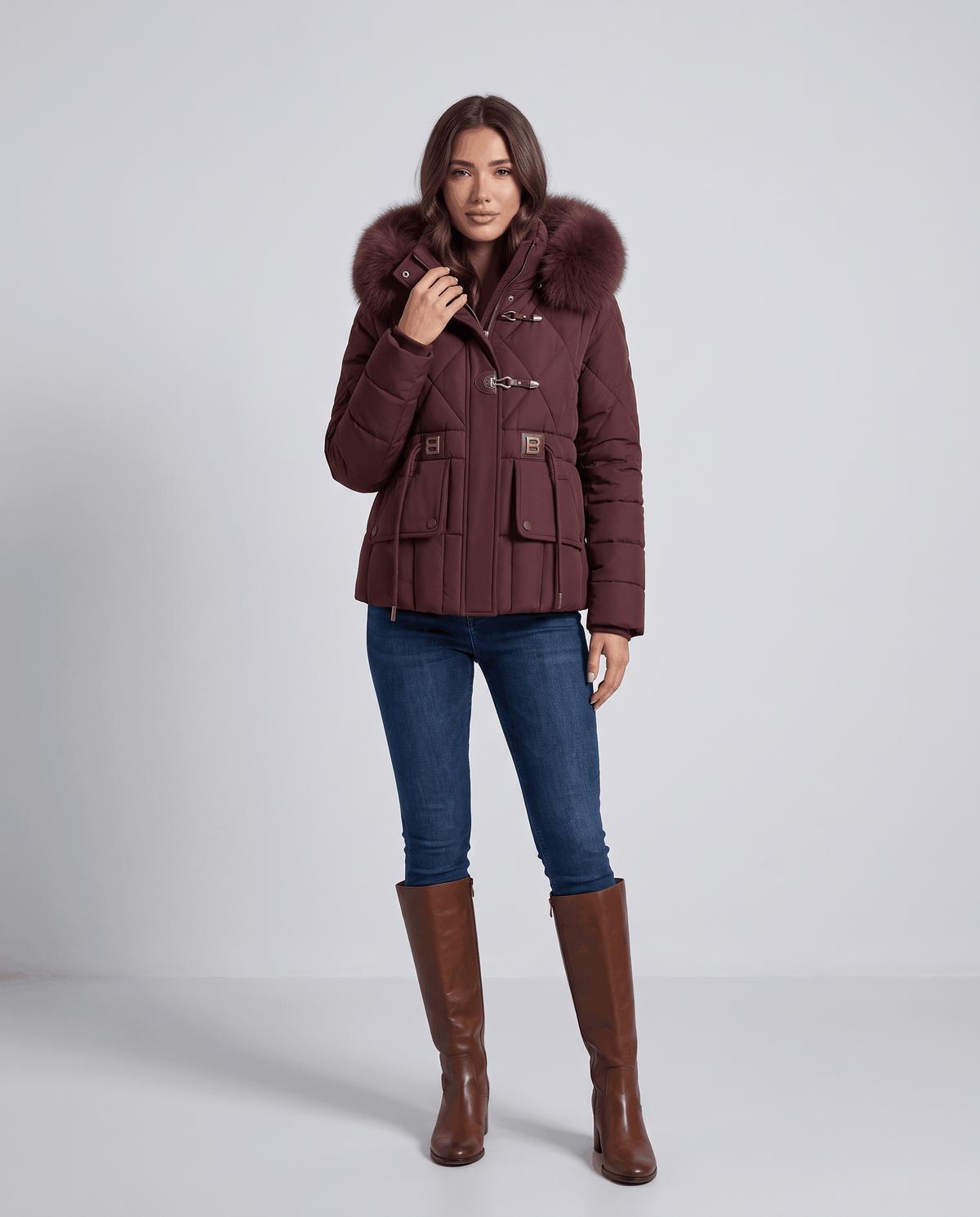 Full-length view of model in maroon quilted jacket, jeans and brown boots