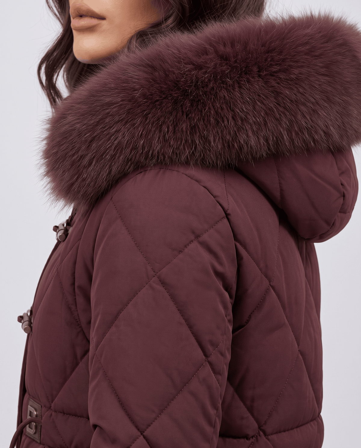 Close-up of maroon plush hood trim and diamond quilted sleeve from the side