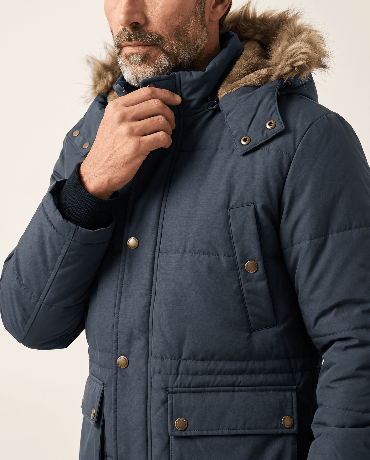 Close-up of dark blue padded chest, snap-button pocket flap and fur-trim hood collar