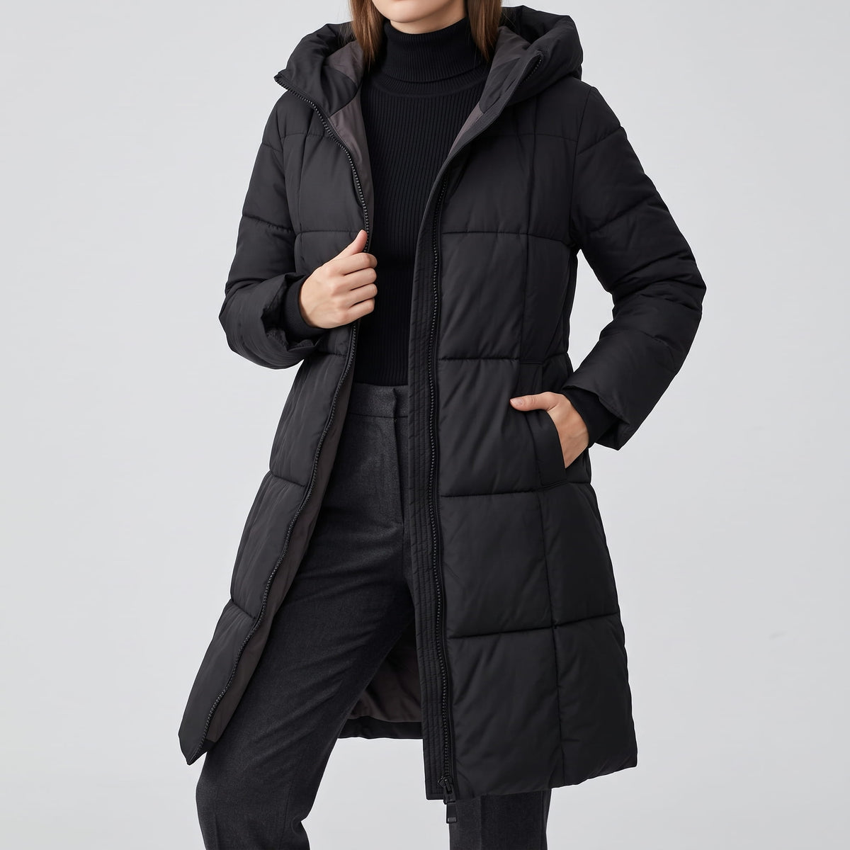 Black quilted coat worn open over a black top and jeans