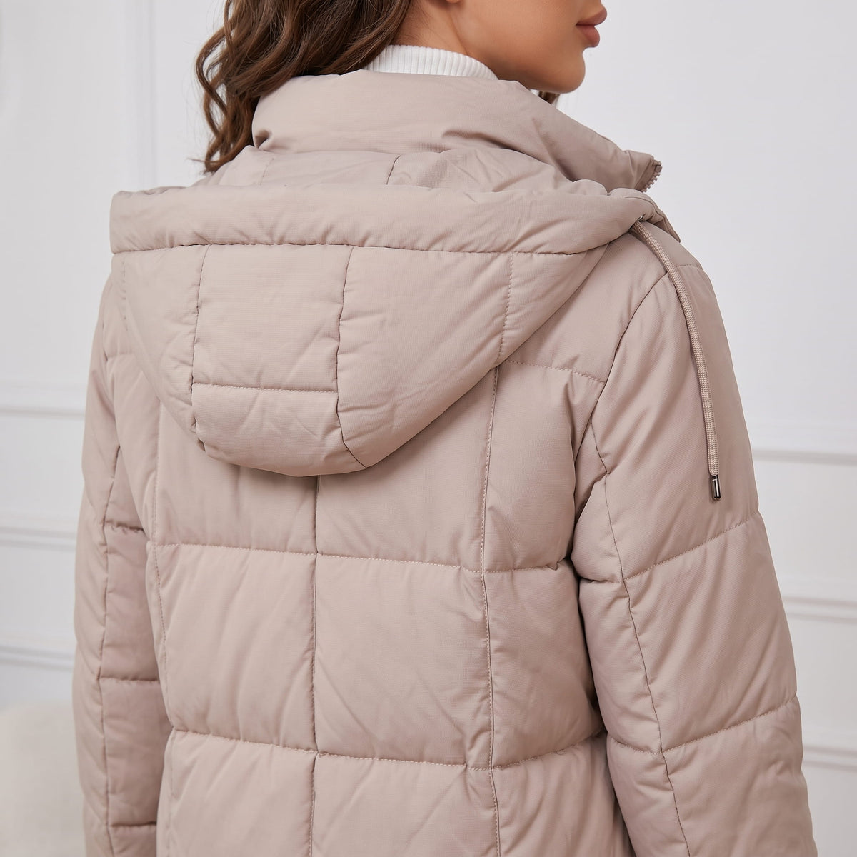 Back detail of taupe coat showing the hood and quilted panels