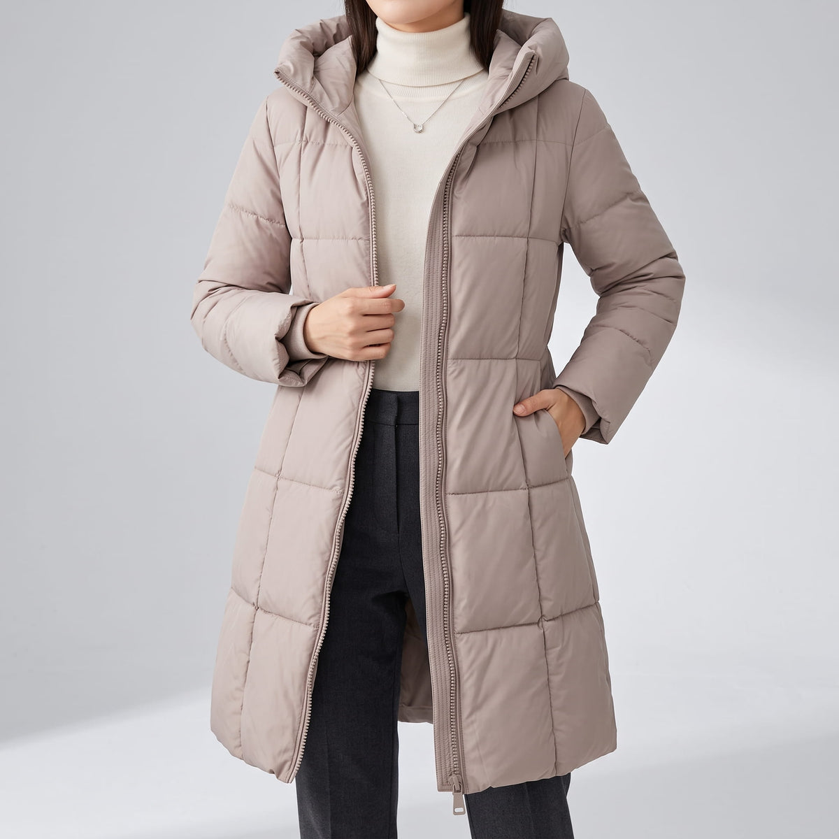 Taupe coat worn open over a white top and black trousers