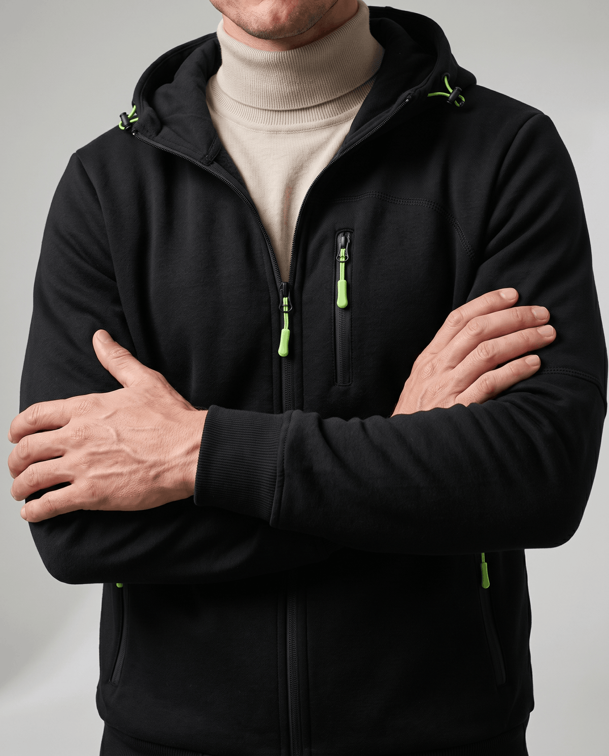 Black hoodie with neon green zip pulls over a cream turtleneck