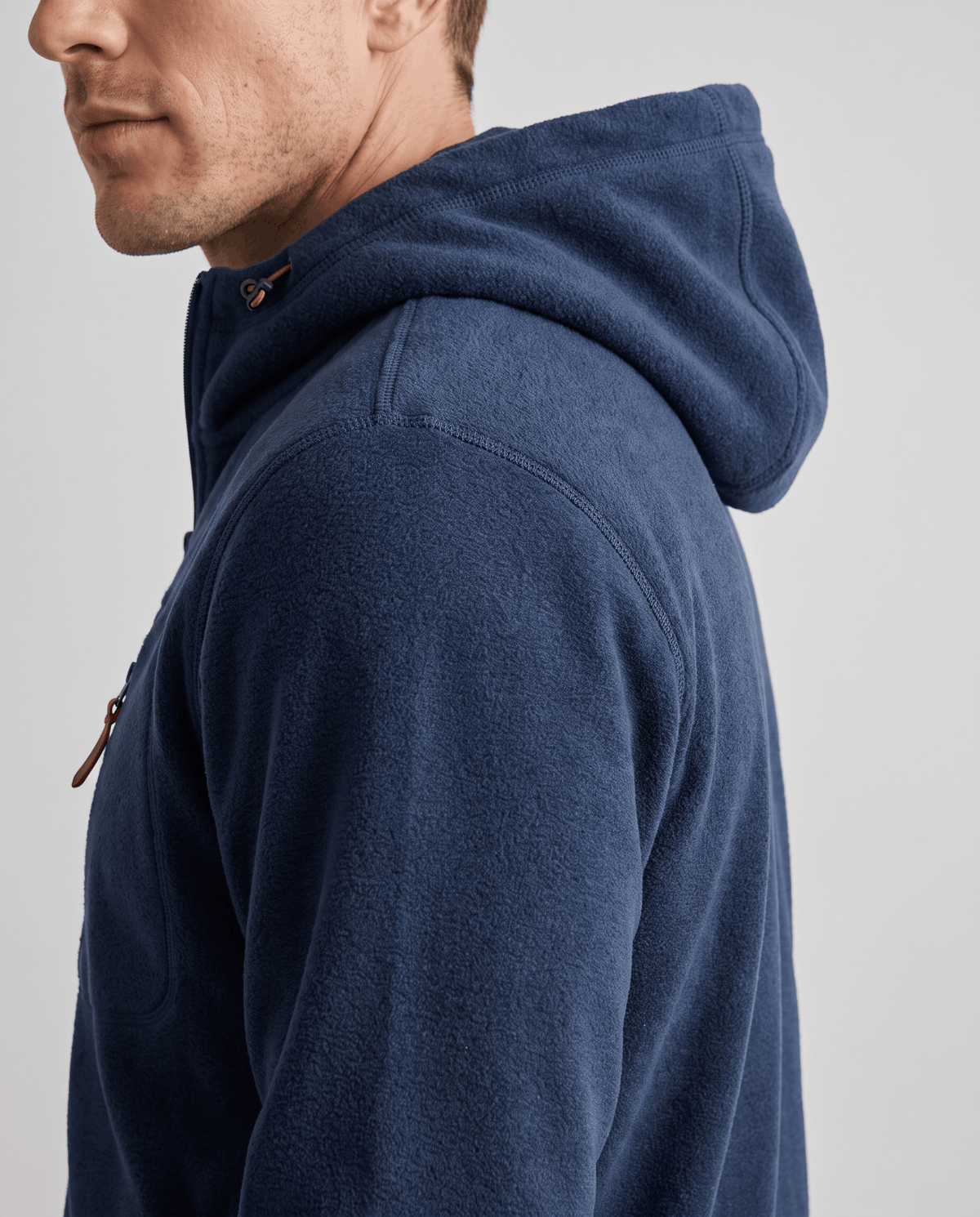 Side view of the navy hoodie's hood and heathered fleece texture