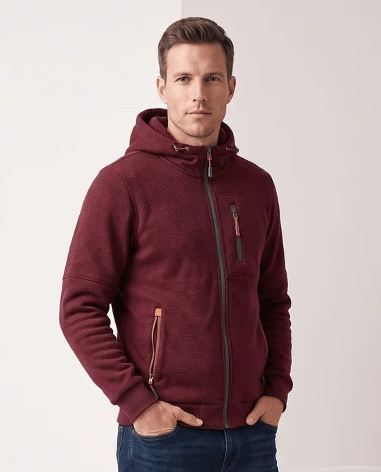 Red hoodie with dark zip pulls and hands in jean pockets