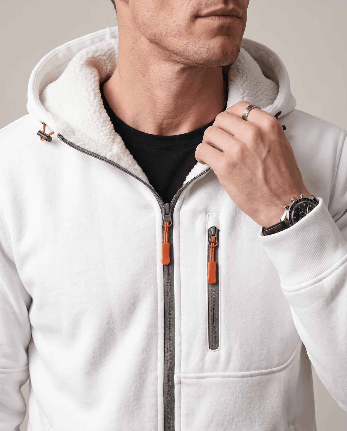 Close-up of the zip and chest pocket with orange pulls on the white hoodie