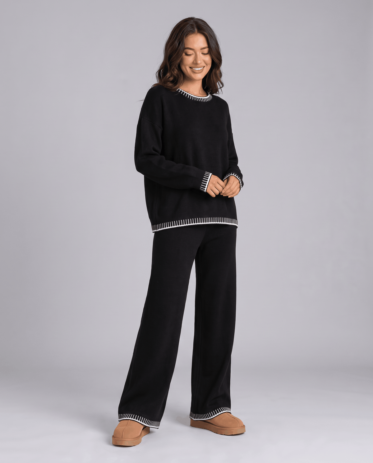 Black knit sweater with light contrast trim and wide-leg pants, front view