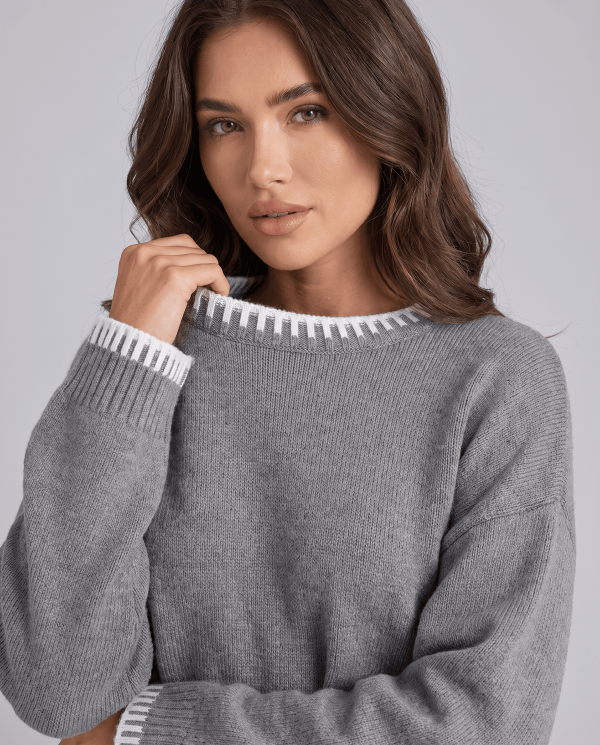 Close-up of the grey knit sweater with contrast trim at the cuff