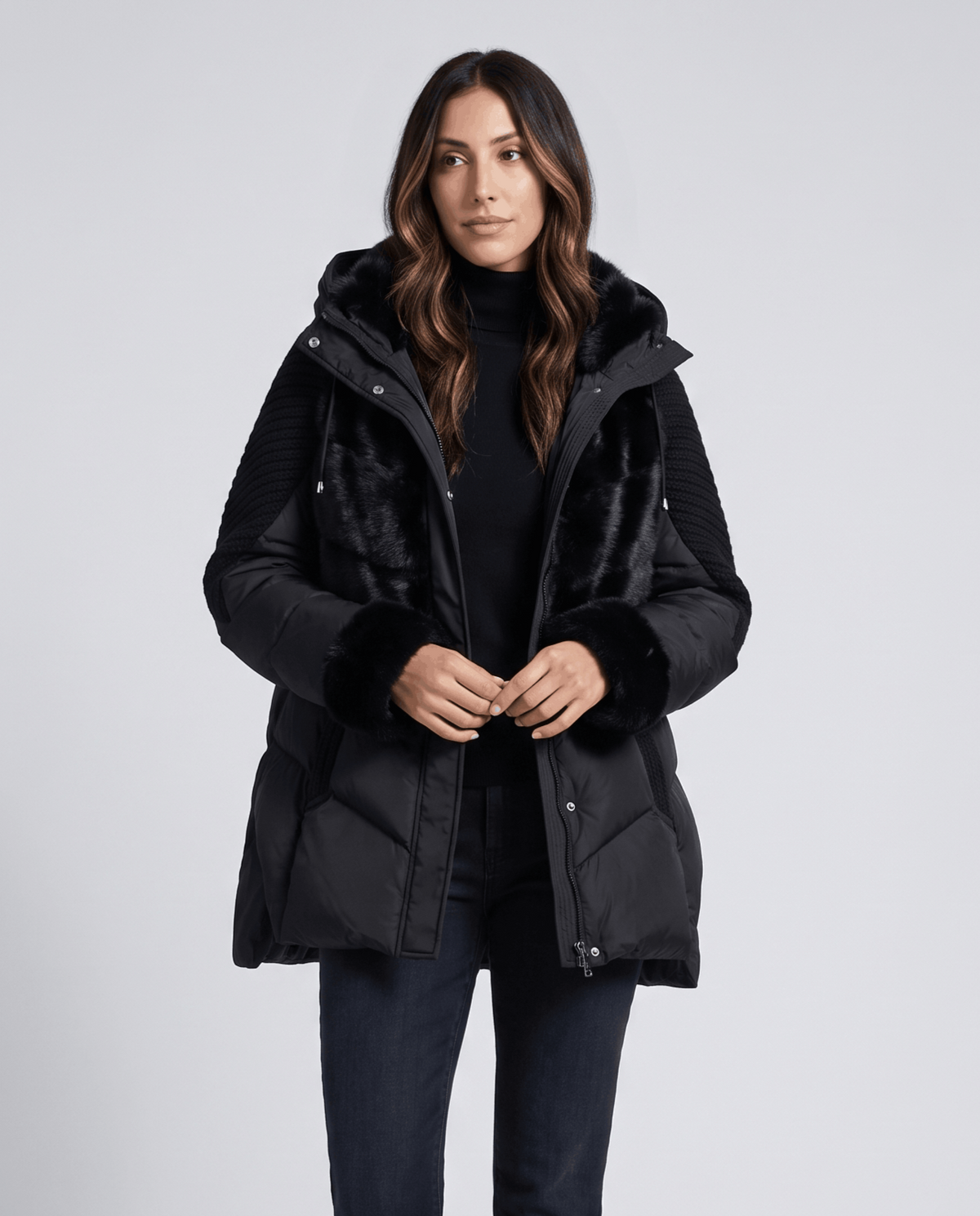 Woman in black knit-panel puffer jacket fastening the snap front