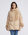 Woman in khaki knit-panel hooded puffer jacket with plush trim and blue jeans