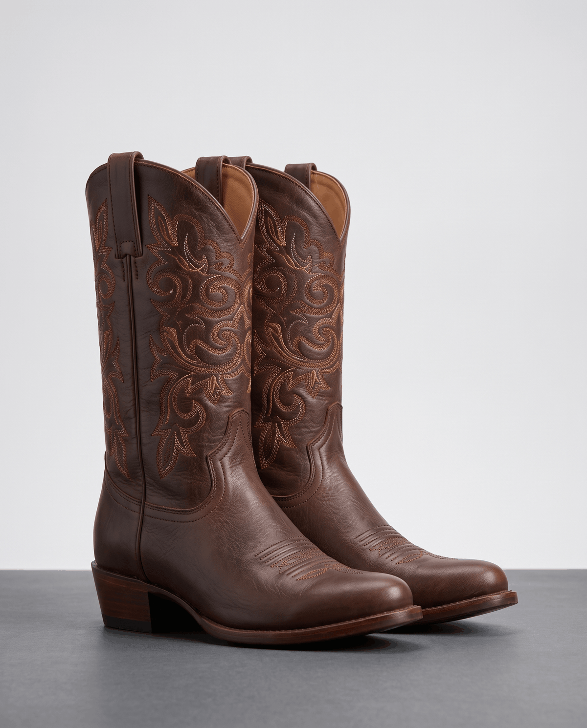 Pair of women's leather cowboy boots in dark brown with embroidered shaft and stacked heel