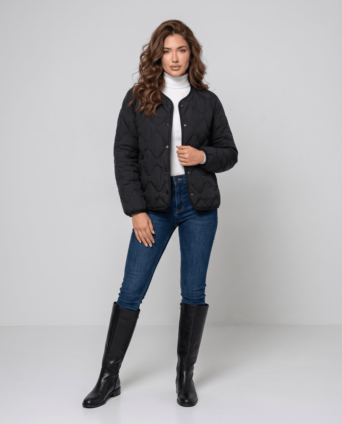 Full-length view of model in black quilted jacket, jeans and black tall boots