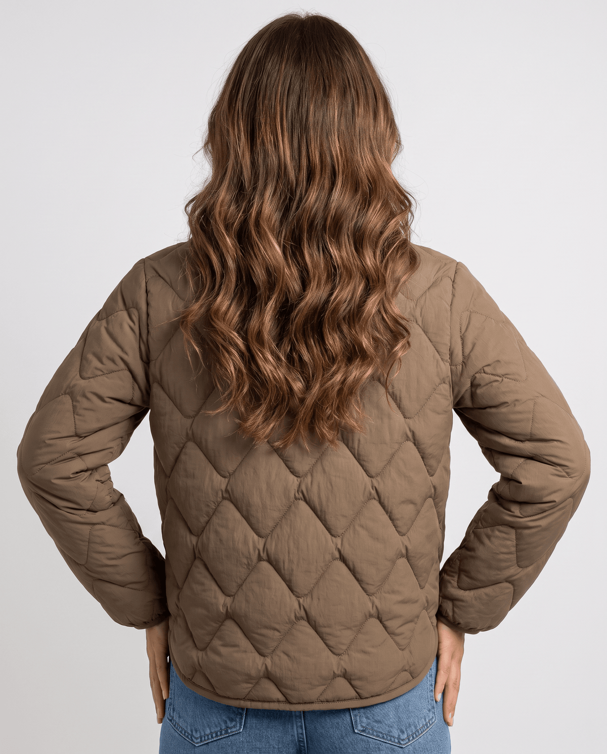 Back view of brown quilted jacket with diamond stitching and long wavy hair