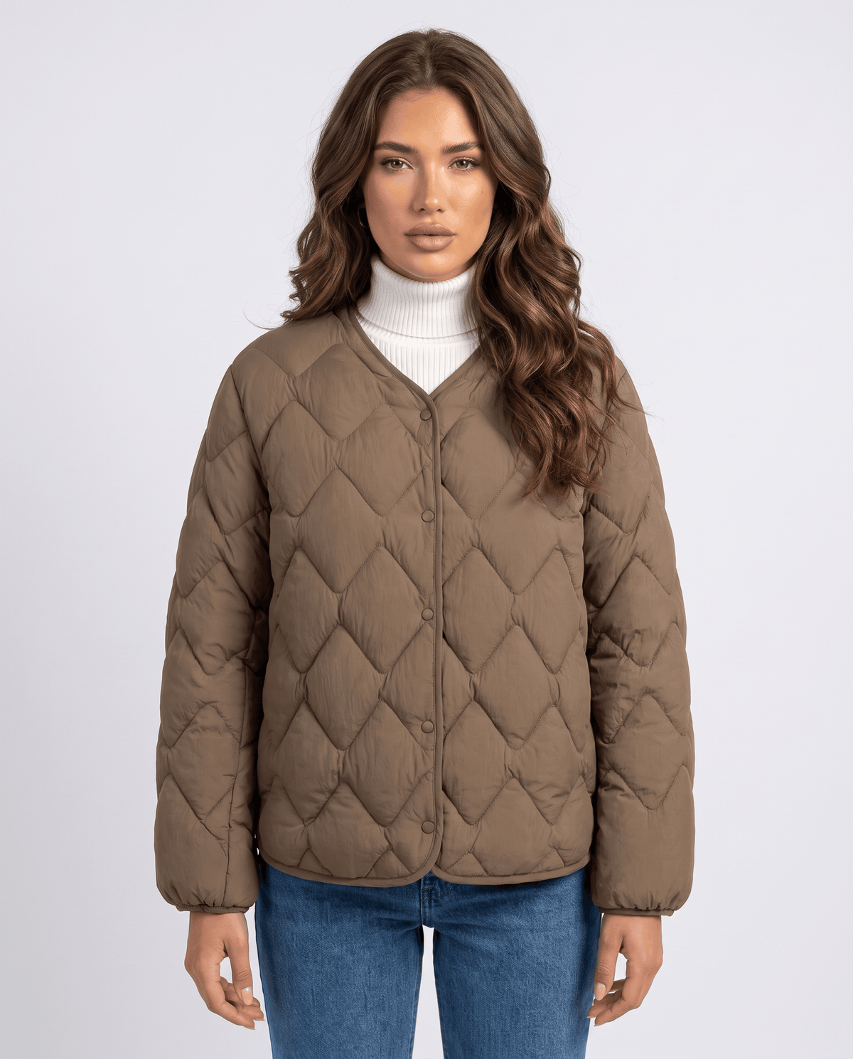Model in brown quilted jacket with collarless V-neck over white turtleneck, front view