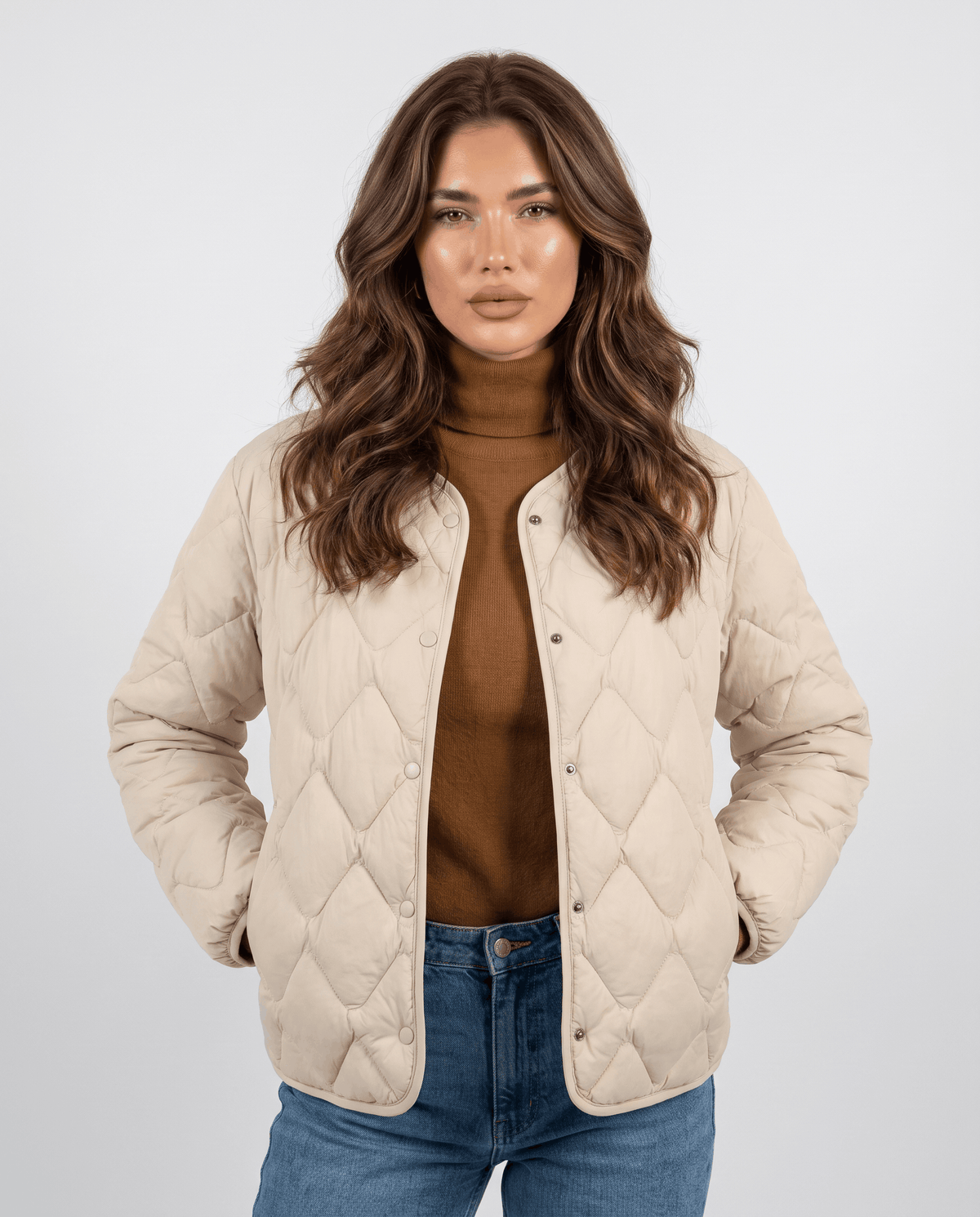 Woman wearing lightweight duck down jacket in cream with diamond quilting and snap front