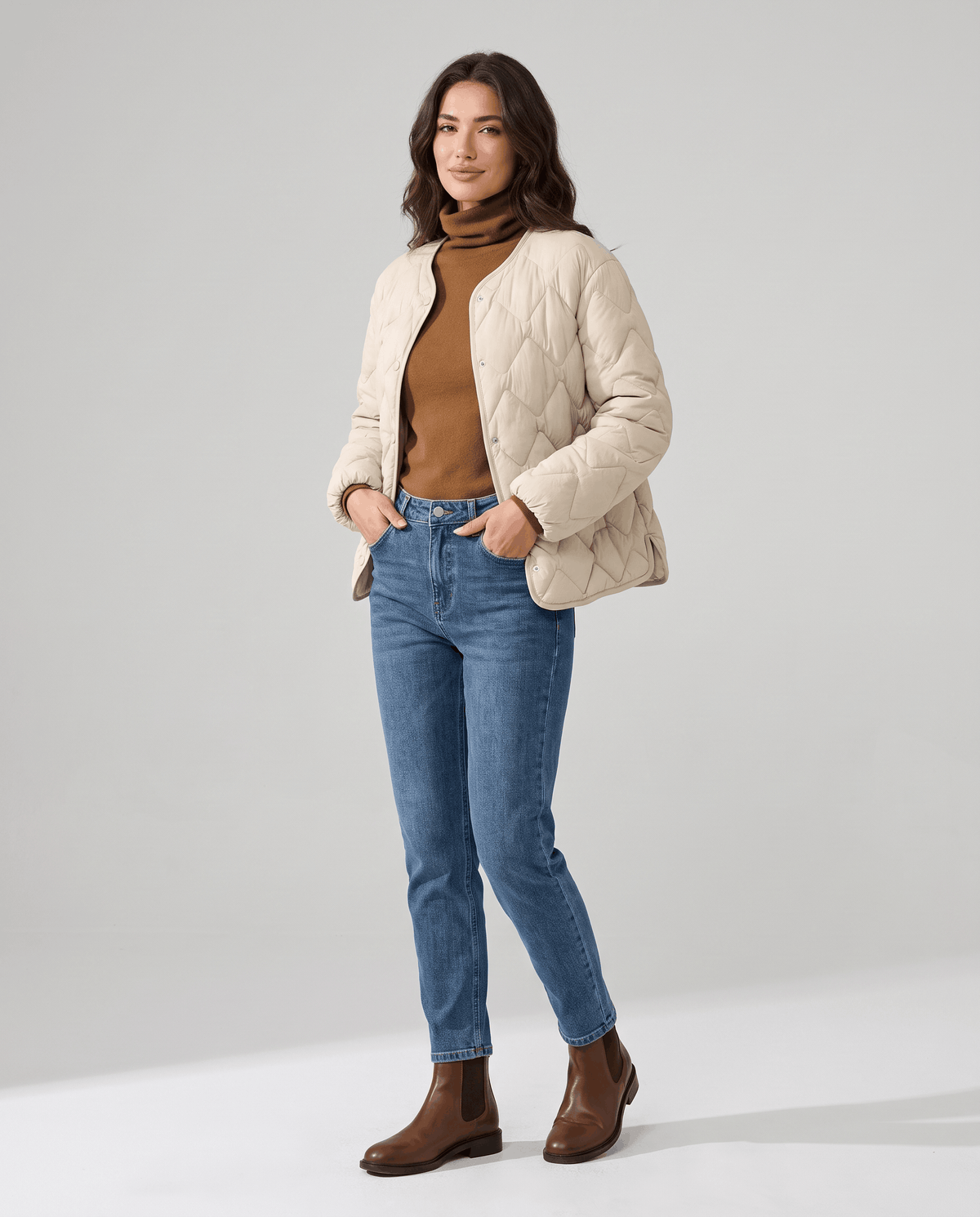Full-length view of model in cream quilted jacket, blue jeans and brown ankle boots