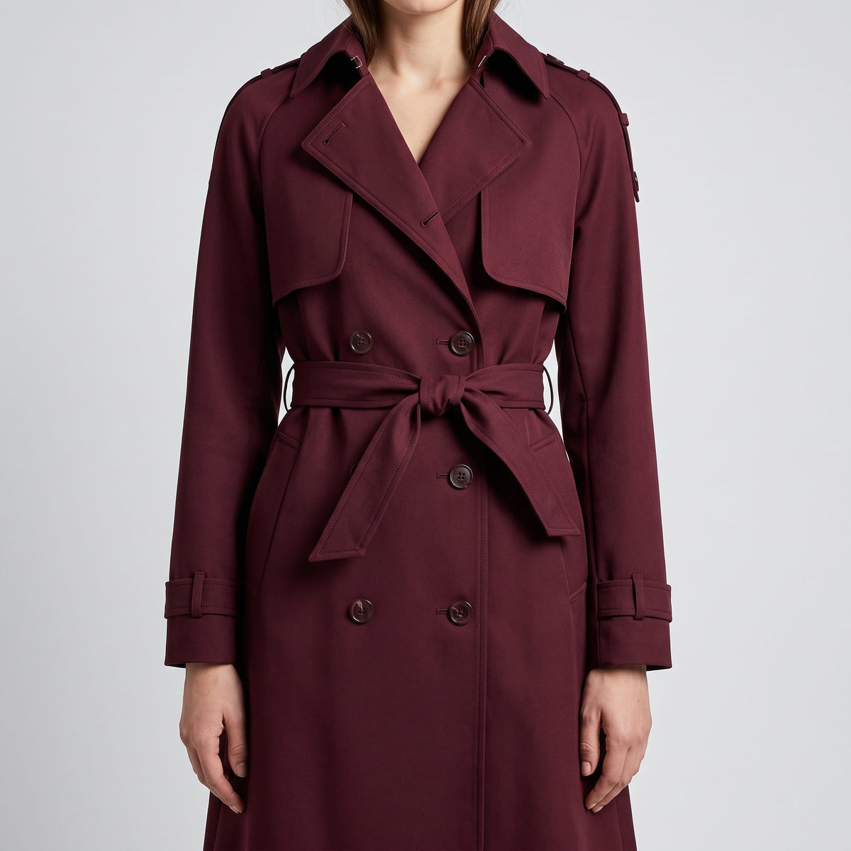 Burgundy coat front with tied belt, double-breasted buttons and cuff straps