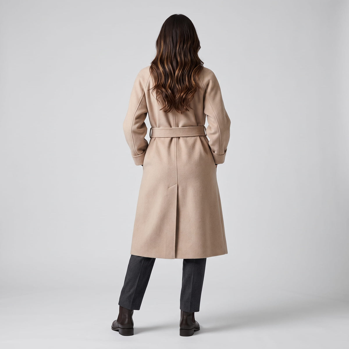Back view of beige coat showing the belted waist and center back vent