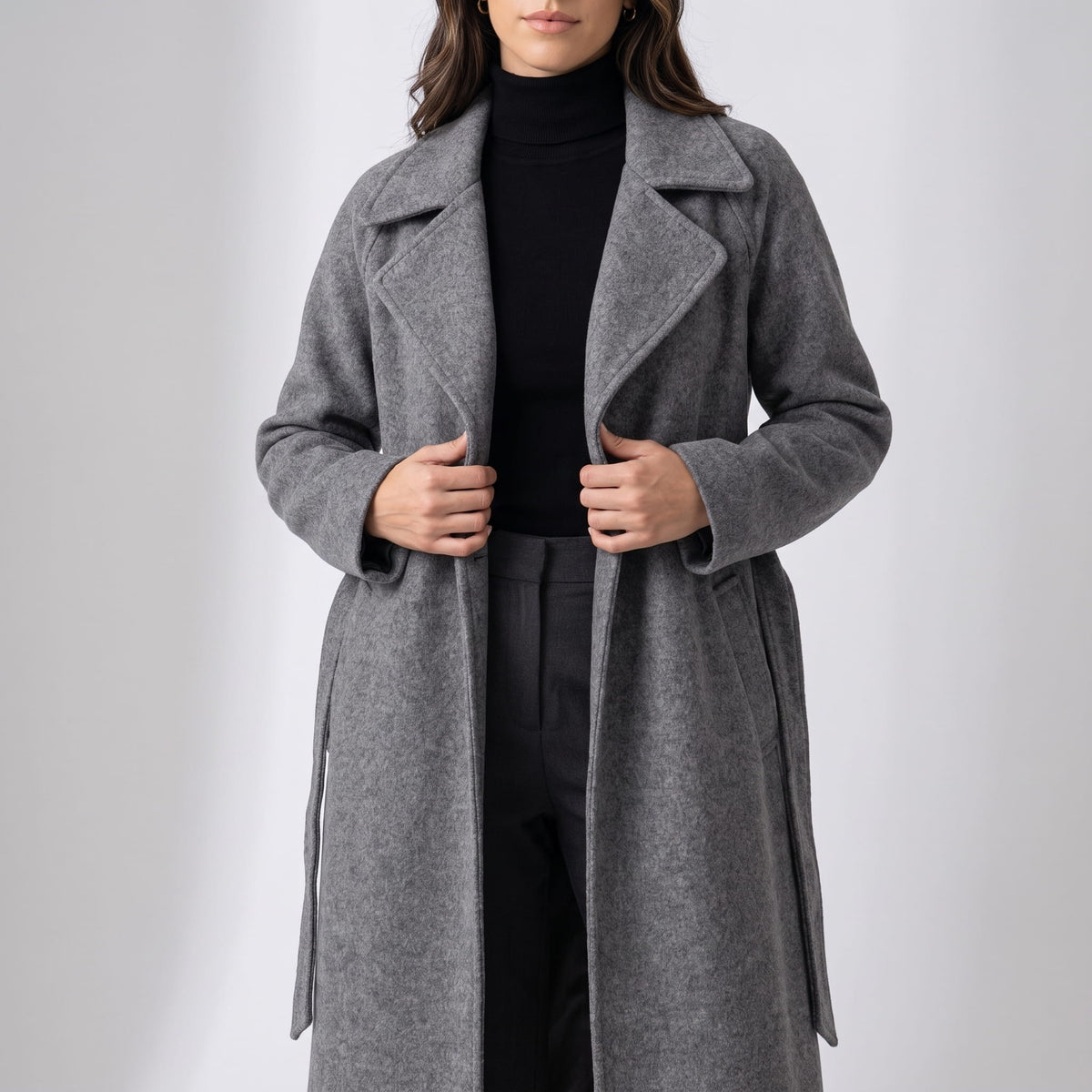 Gray coat worn open over a black turtleneck with the belt hanging loose