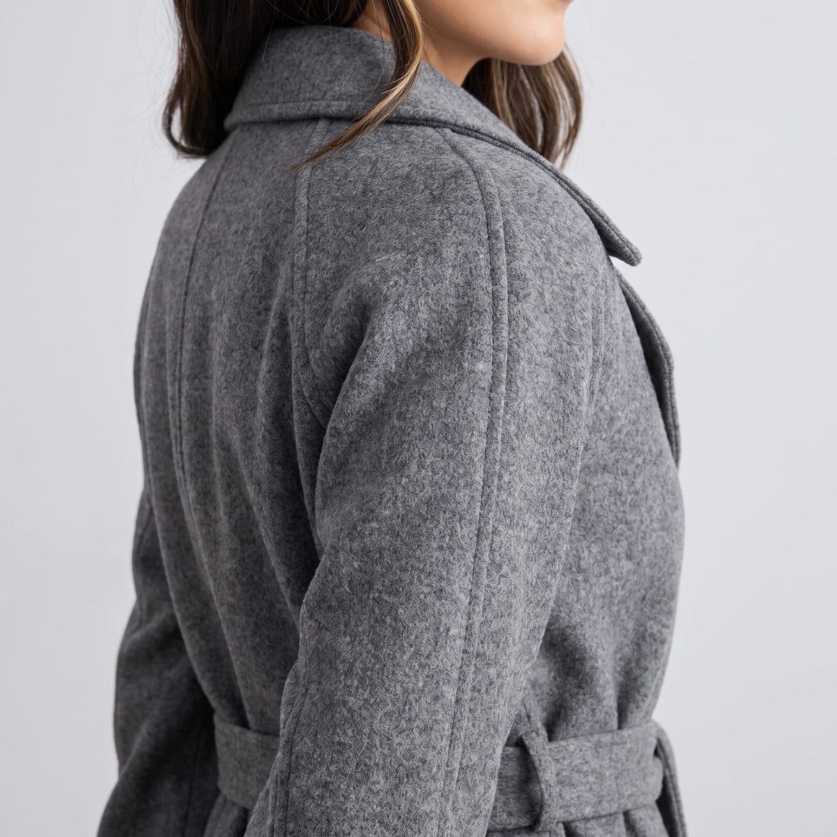 Rear shoulder detail of gray coat showing the collar and belted waist