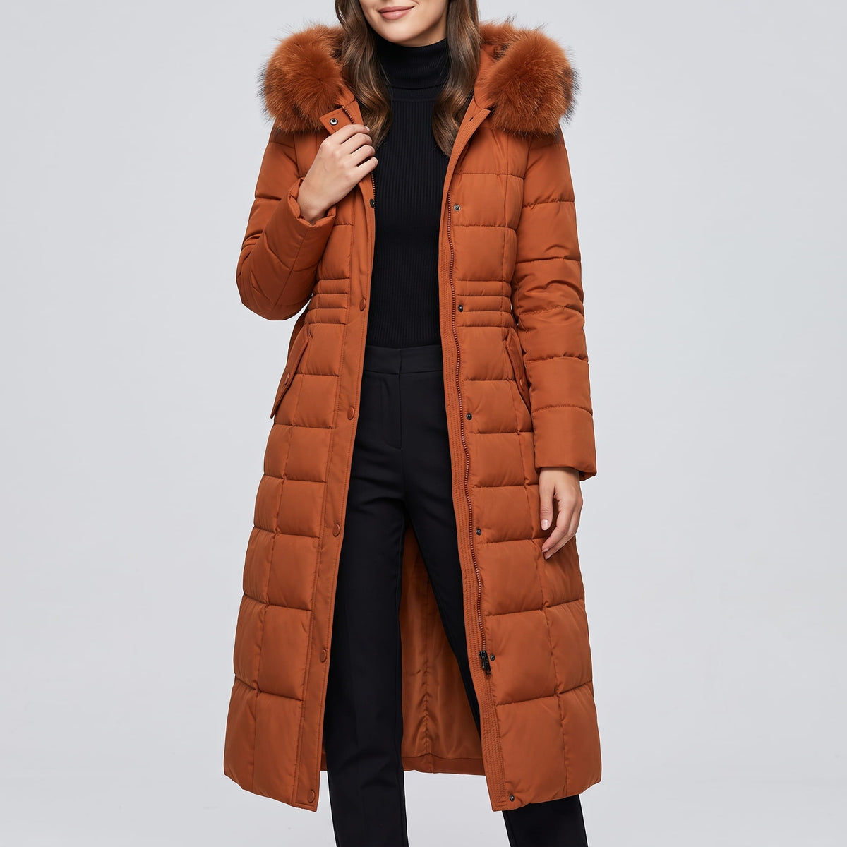 Caramel coat worn open over a black top and dark trousers