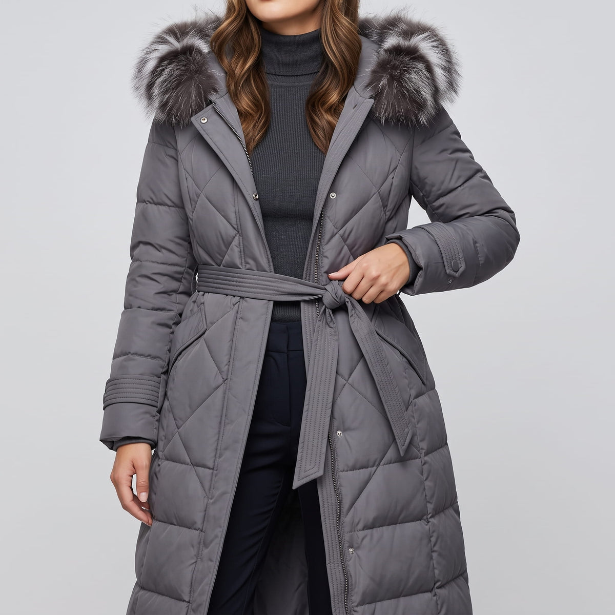 Gray coat belted at the waist over a charcoal turtleneck