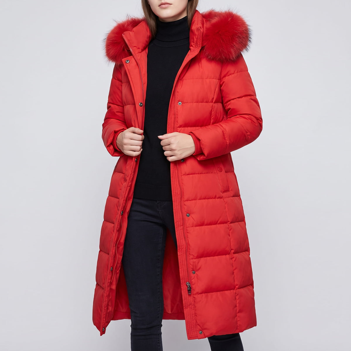 Red coat worn open over a black turtleneck and dark jeans
