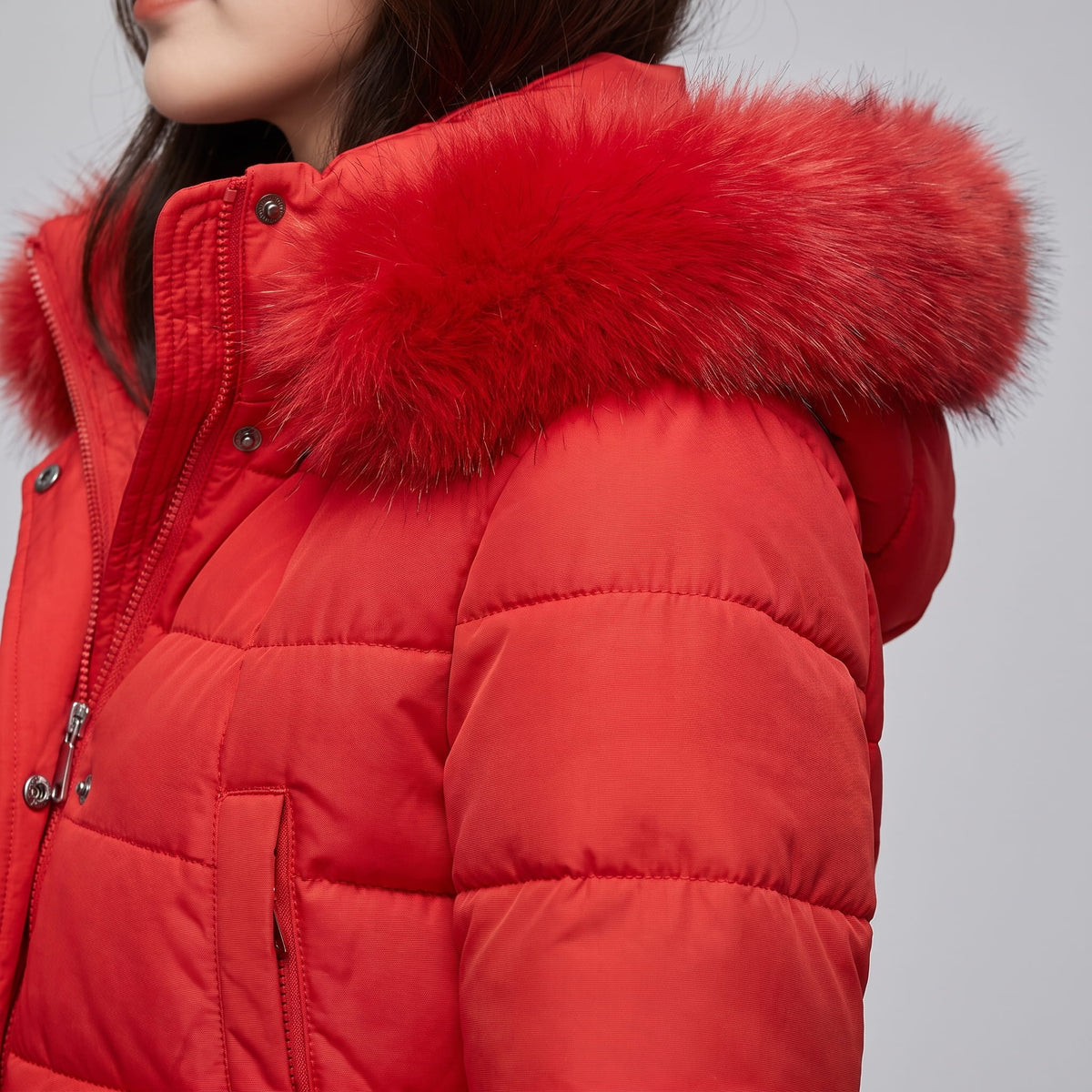 Close-up of red coat snap placket and plush hood trim