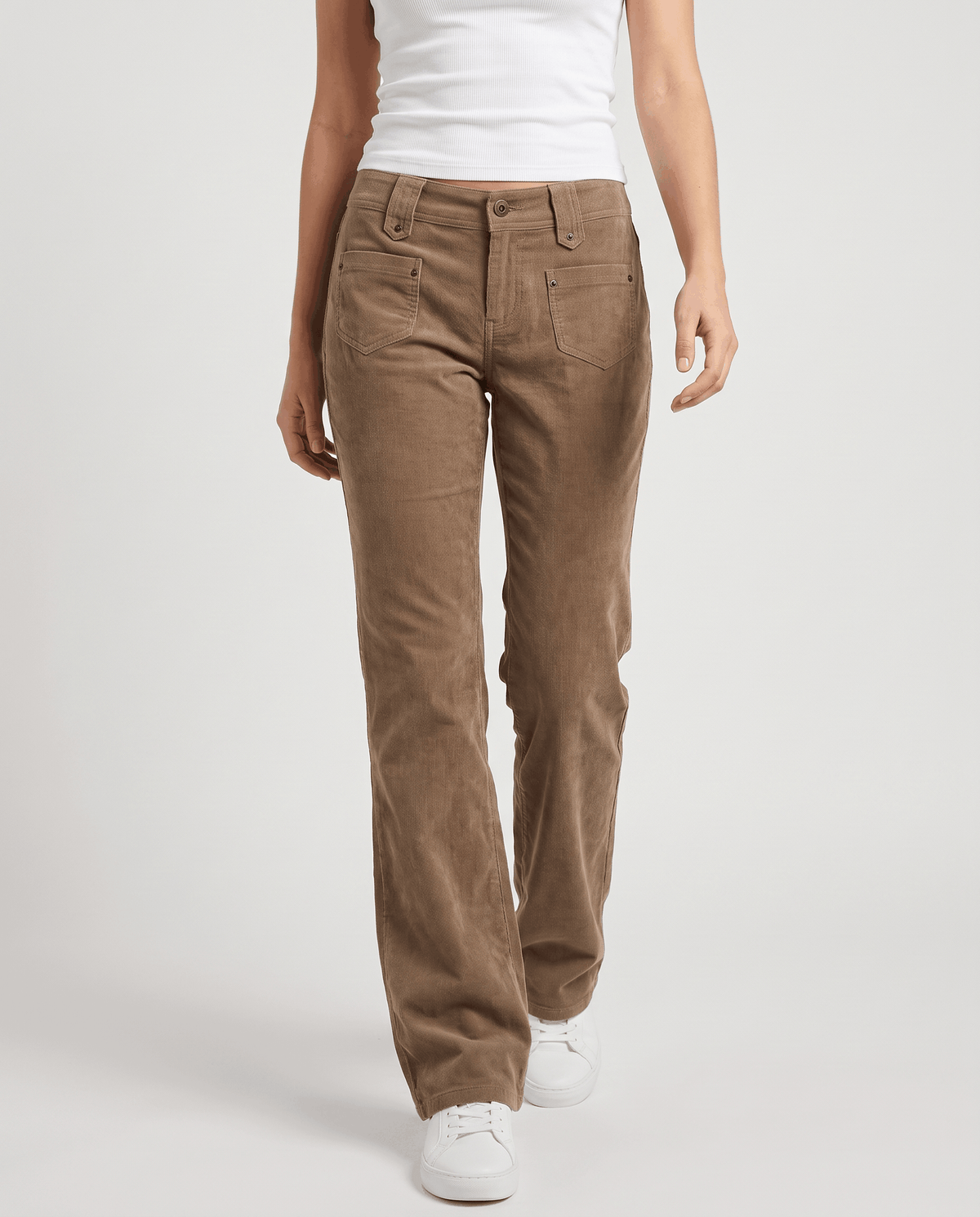 Woman wearing khaki low-rise corduroy flare pants with white sneakers, front view