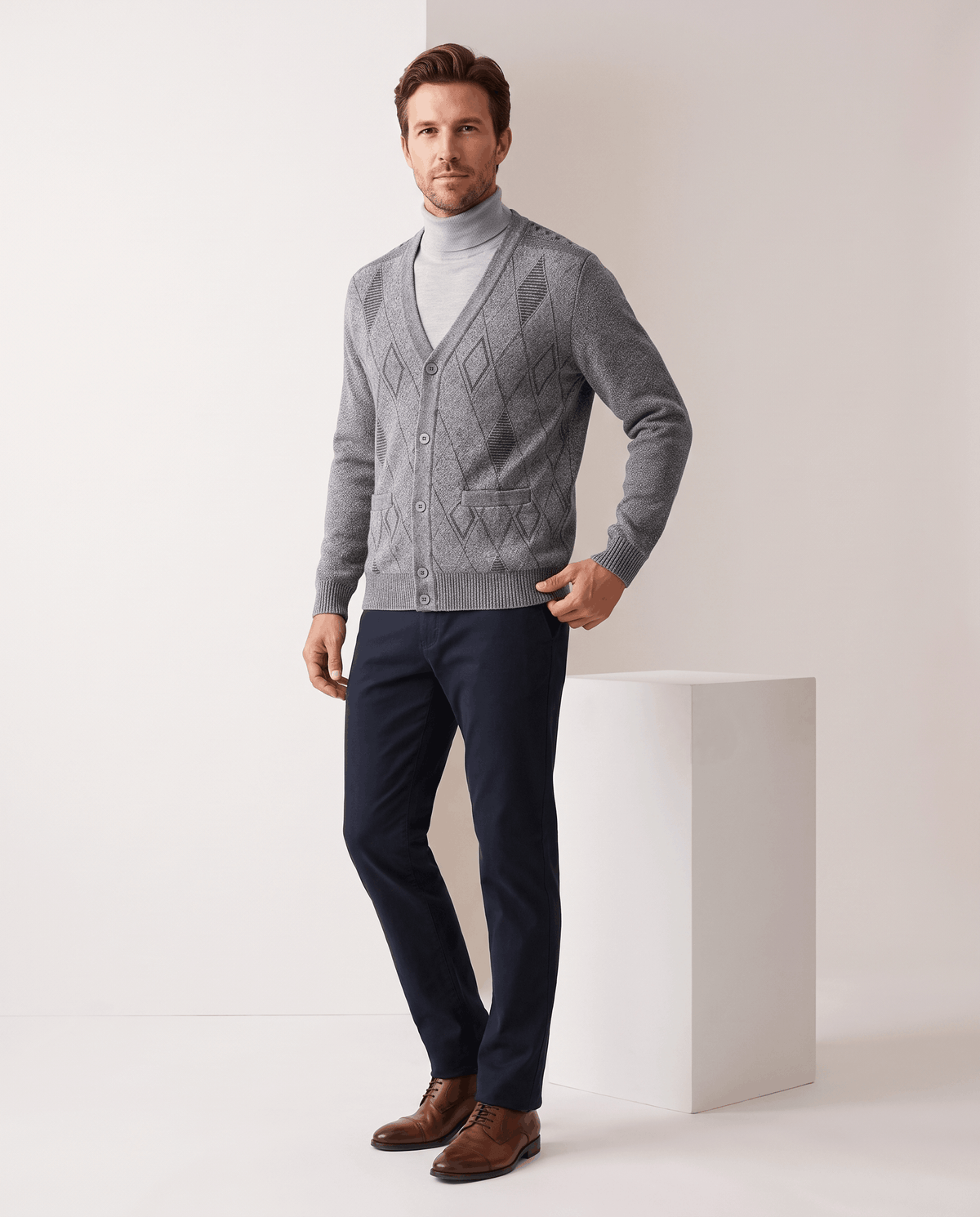Full-length view of the light gray cardigan with navy trousers and brown shoes