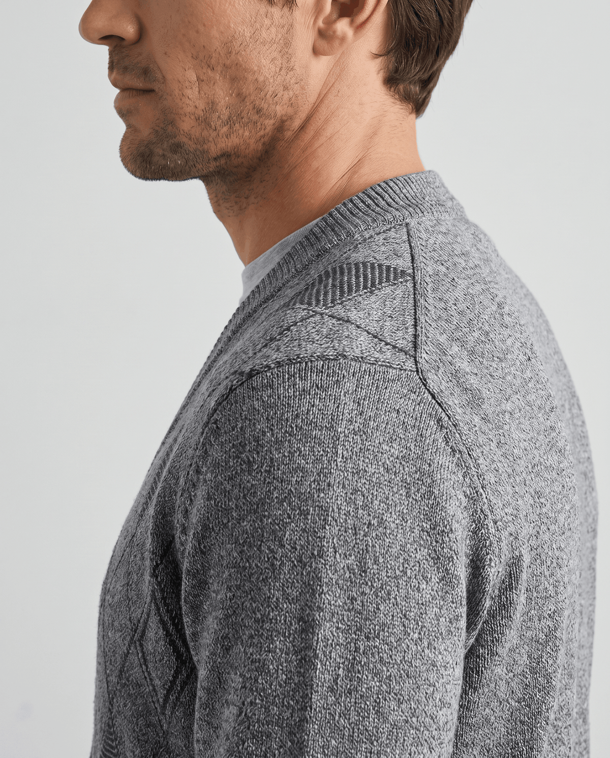 Side close-up of the light gray marled knit at the shoulder and V-neck