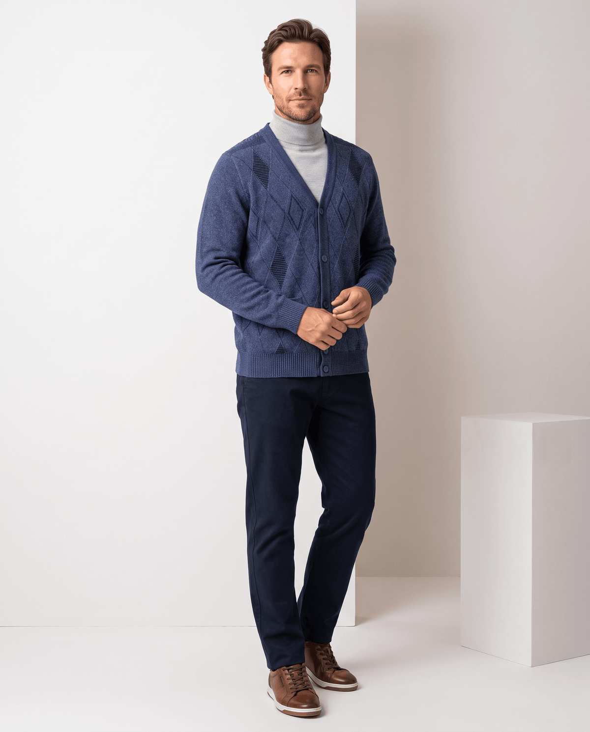 Full-length view of the navy cardigan buttoned with navy trousers and brown shoes