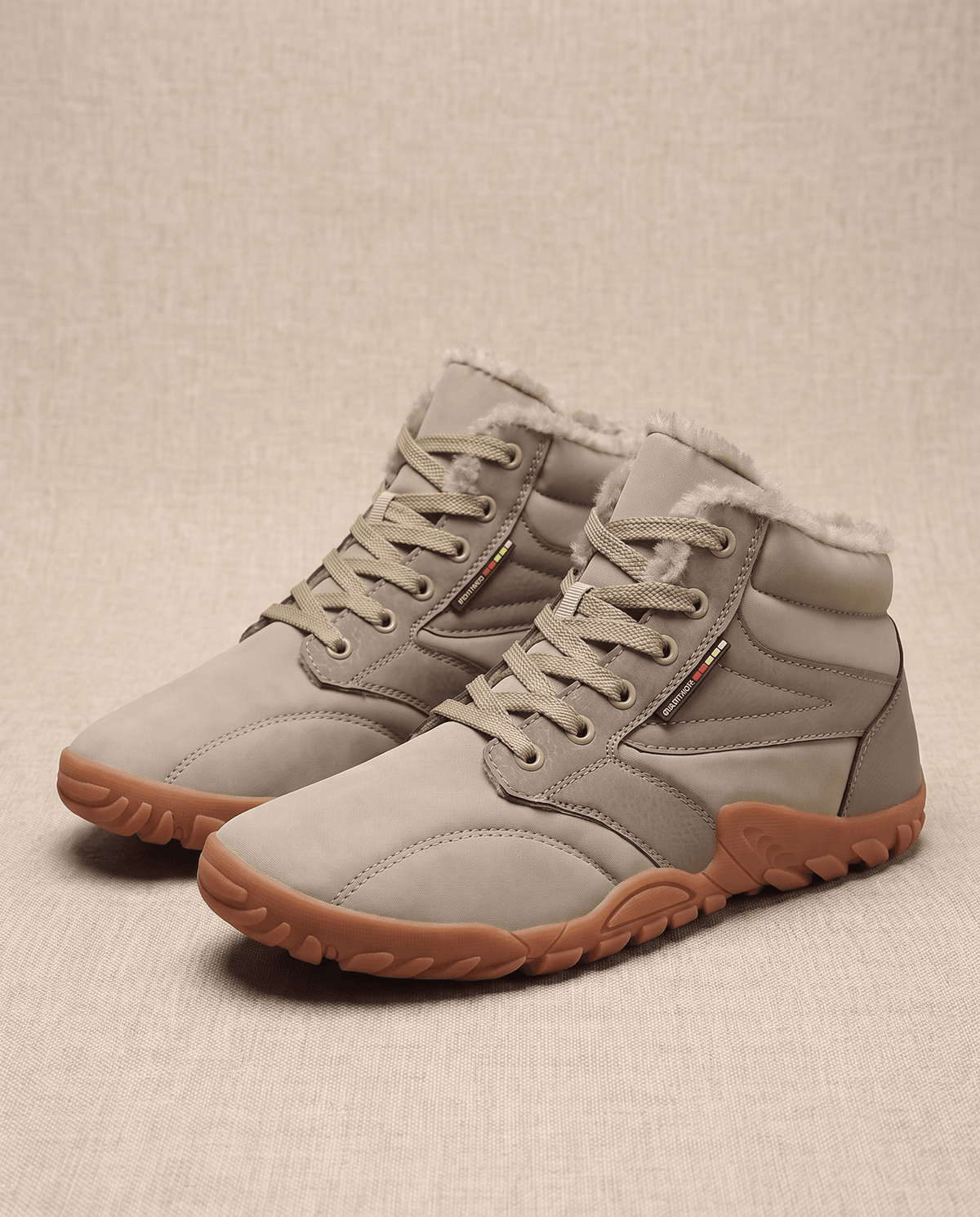 Beige pair angled on a warm backdrop with a contrast gum-toned flexible outsole