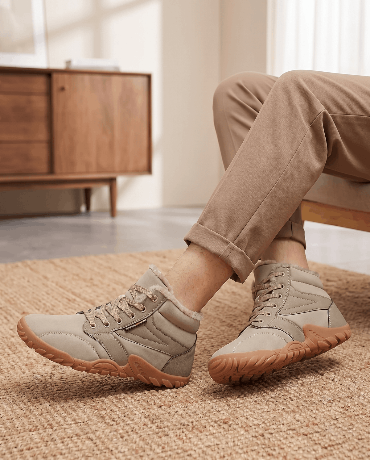 Beige boots worn with tan trousers beside a wooden stool in a bright room