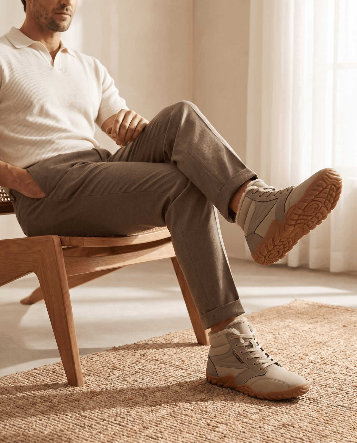 Seated man in olive trousers crossing his legs in beige ankle boots