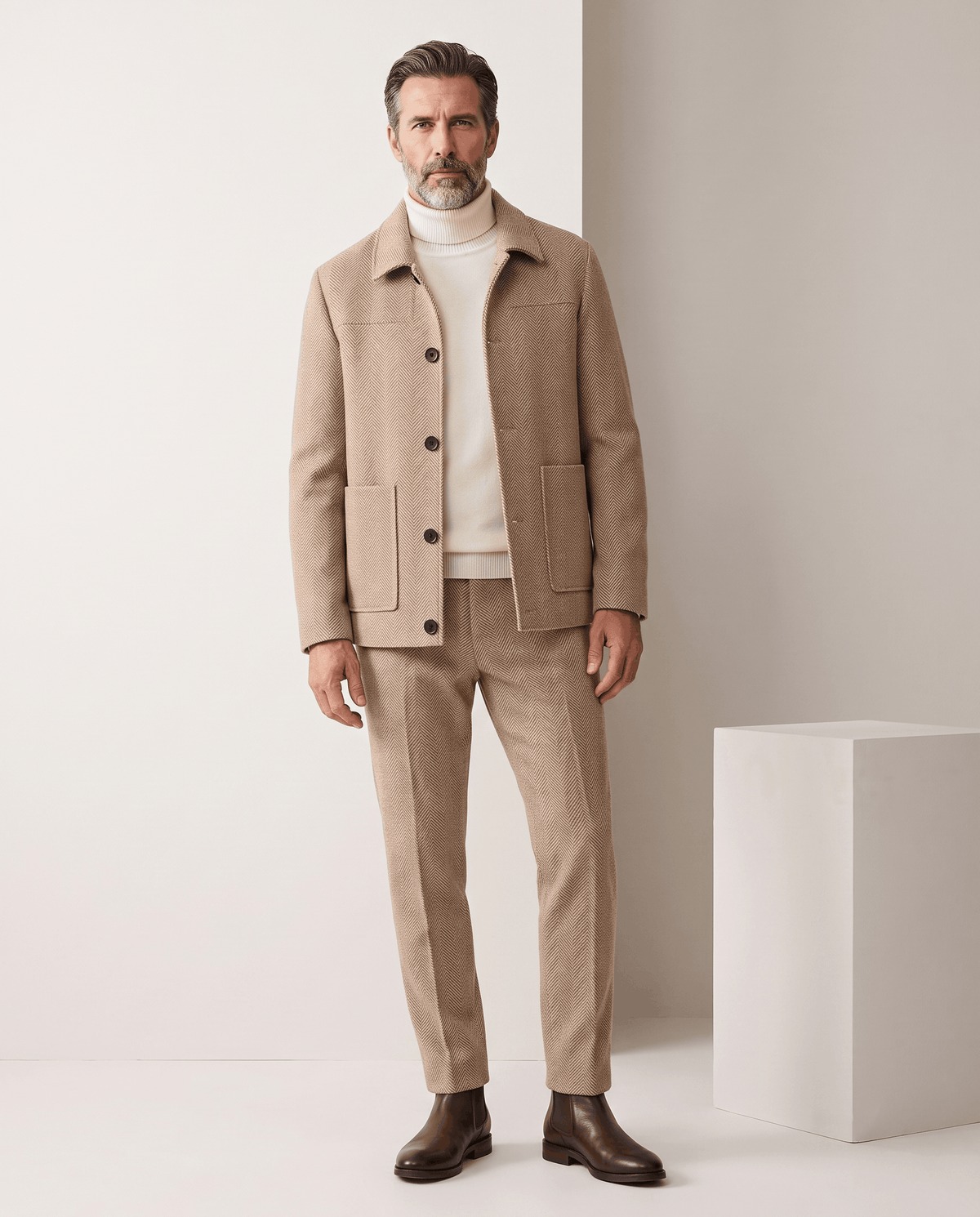 Full-length view of a man wearing the Henrik beige coat with matching trousers