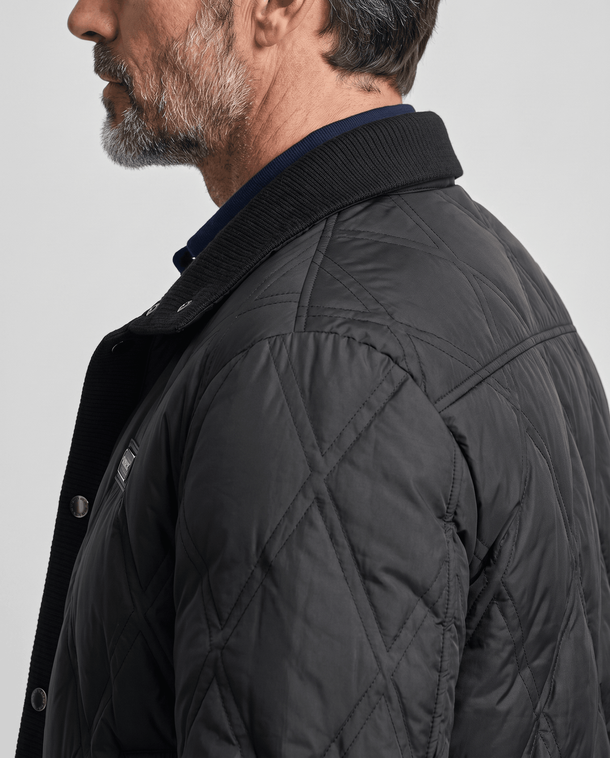 Close-up of the diamond quilting and ribbed collar on a black puffer jacket