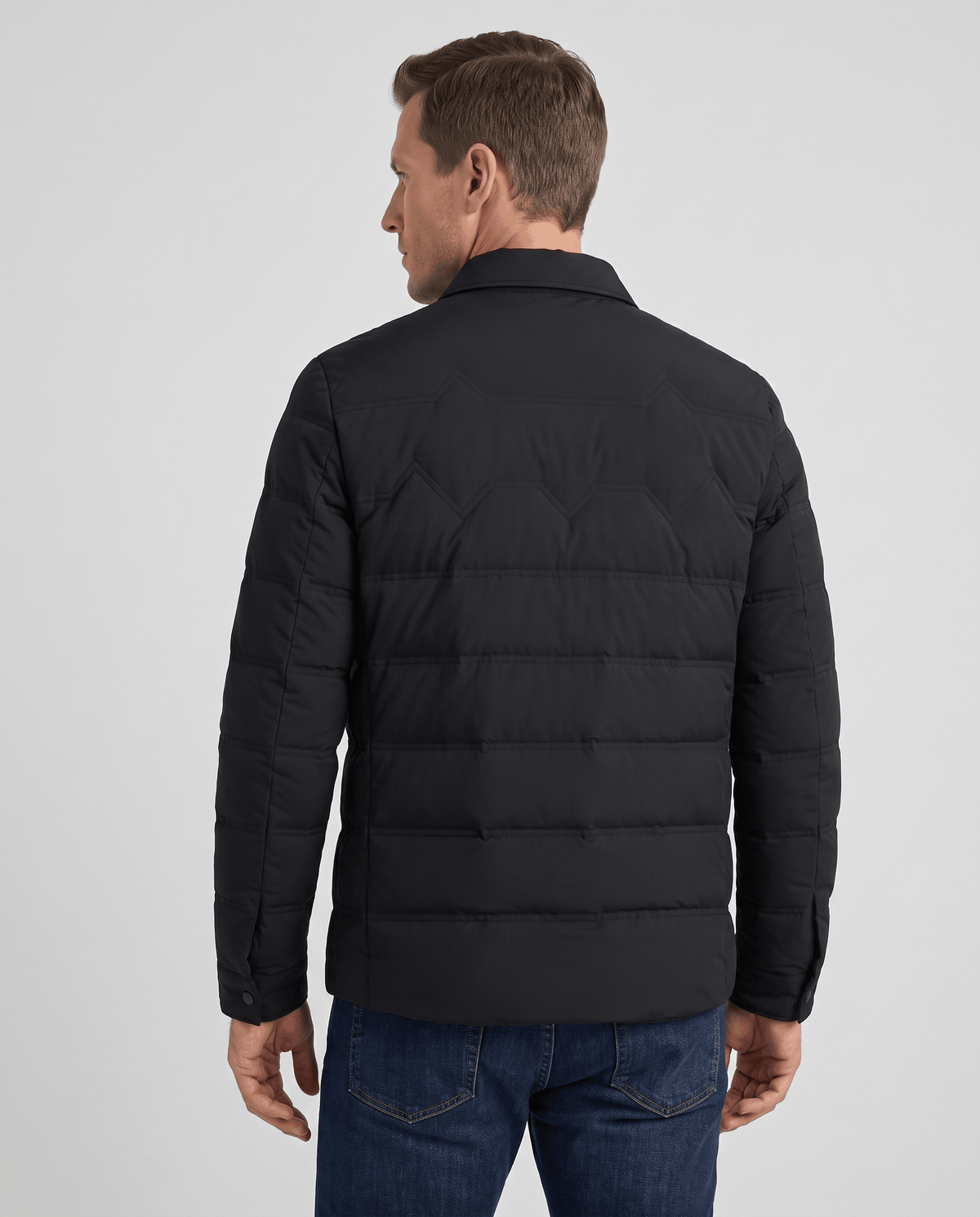 Back view of a man wearing a black quilted puffer jacket