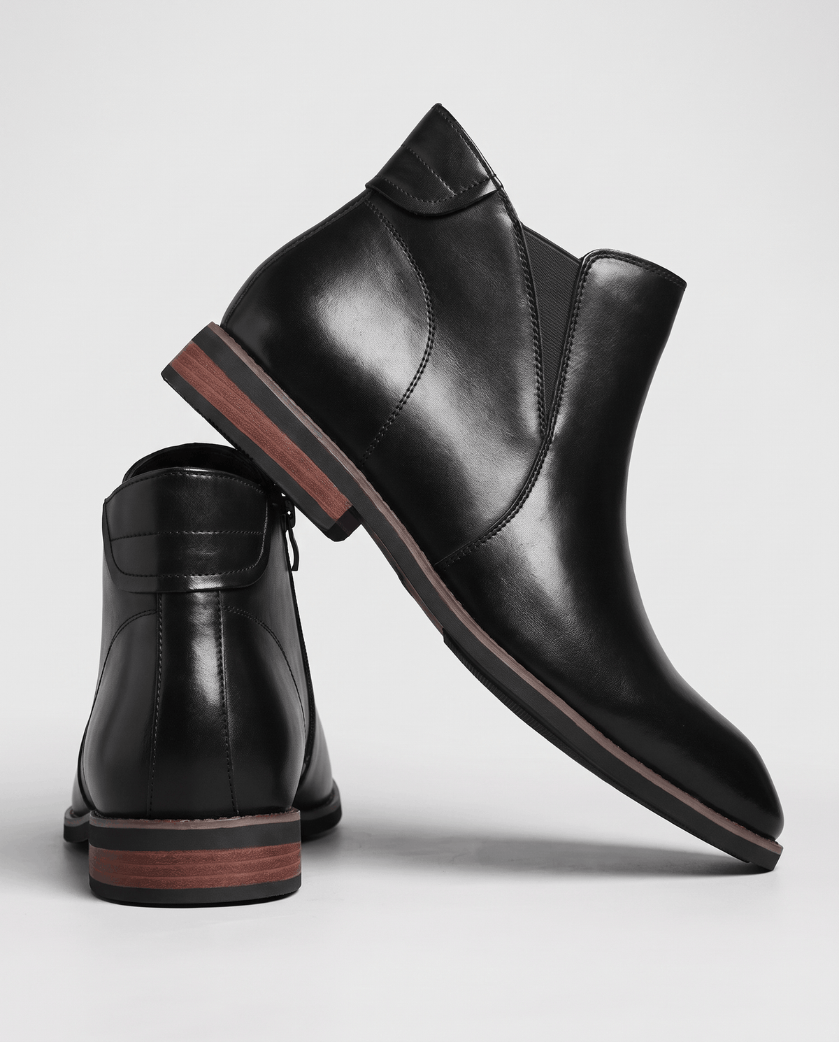 Two black Chelsea boots angled to show the side zip and low heel