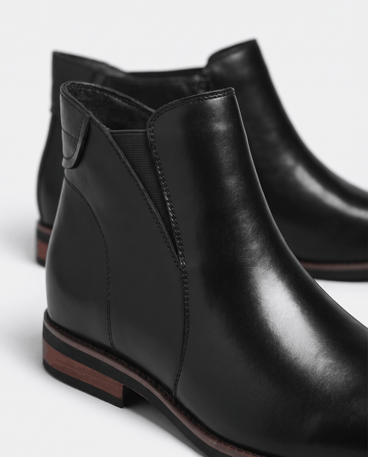 Close-up of a black Chelsea boot with elastic side panel and thin sole