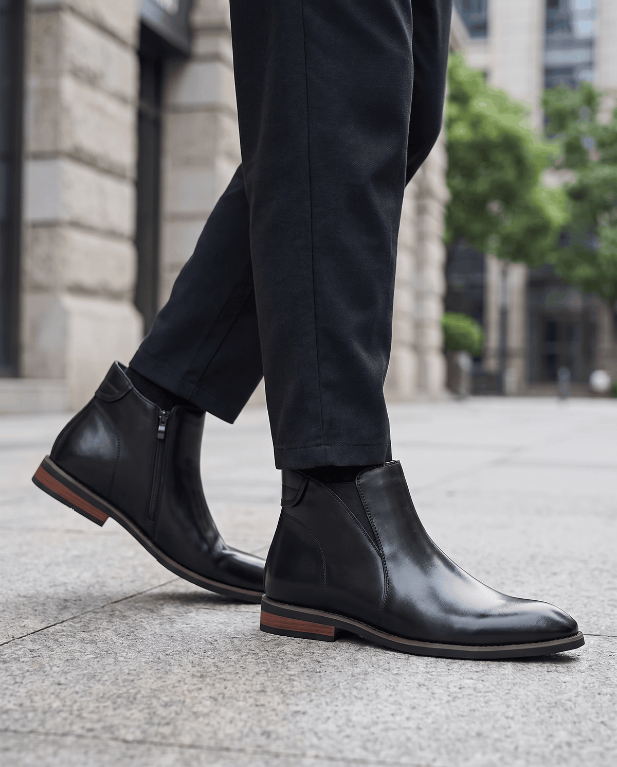 Man walking in black Chelsea boots with dark trousers on a city street