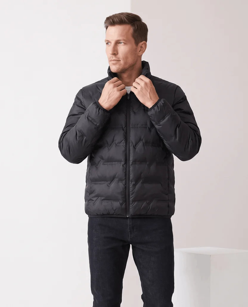 Man wearing a black quilted duck down puffer jacket with stand collar, front view