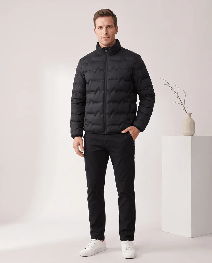 Man standing in a black quilted puffer jacket with dark trousers, full-length view