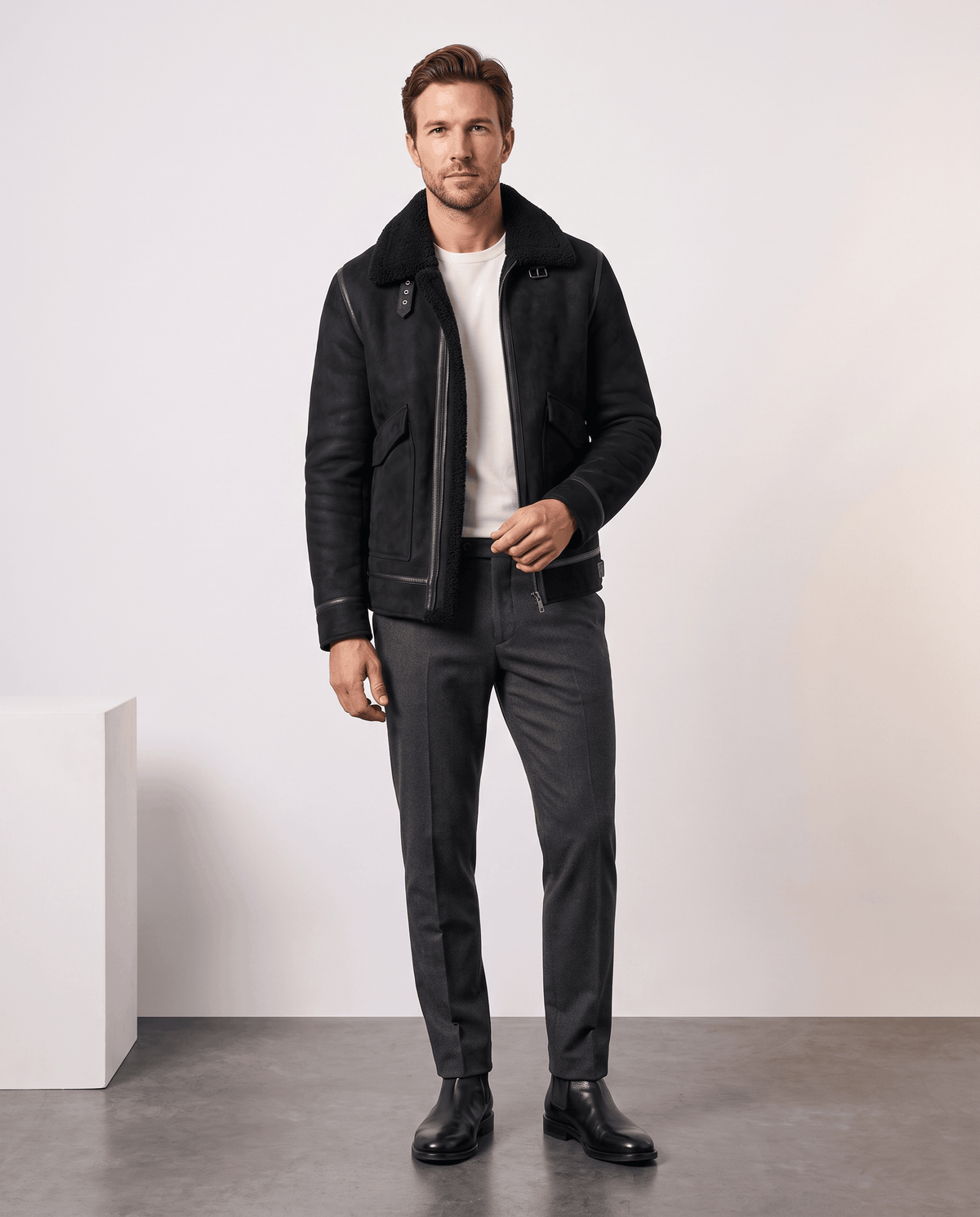 Full-length view of a man wearing the Harlan black aviator jacket with dark trousers