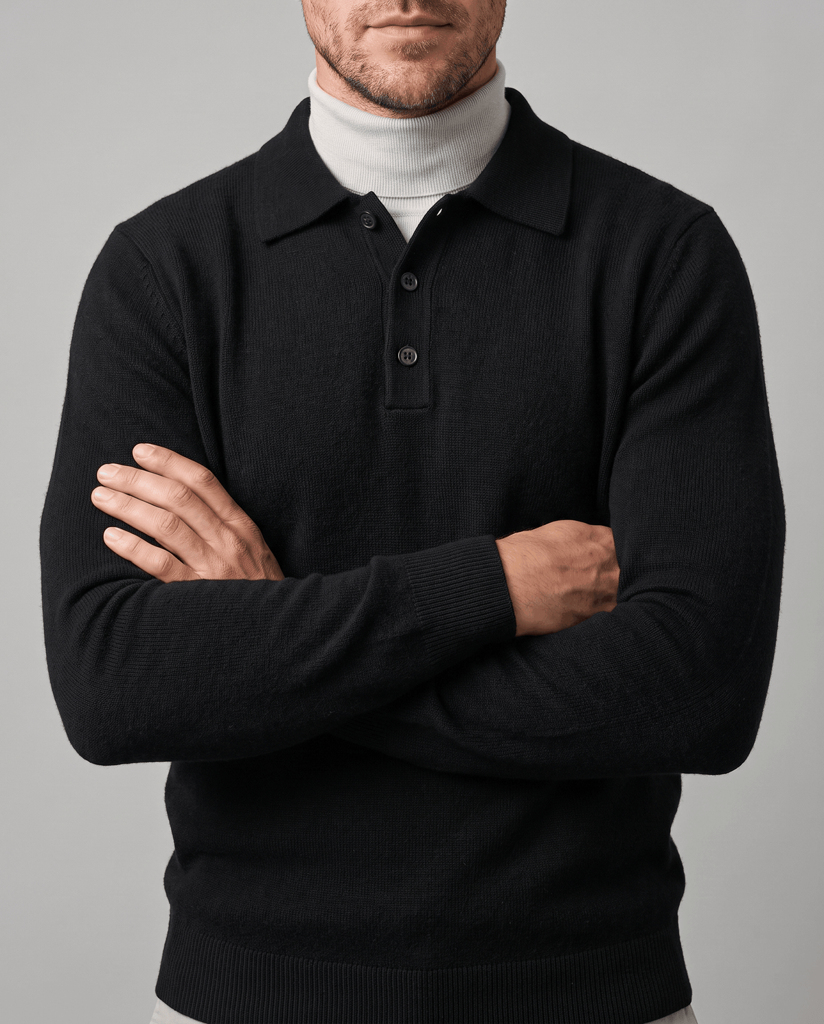 Man with arms crossed wearing the Elias black wool knit polo sweater over a turtleneck