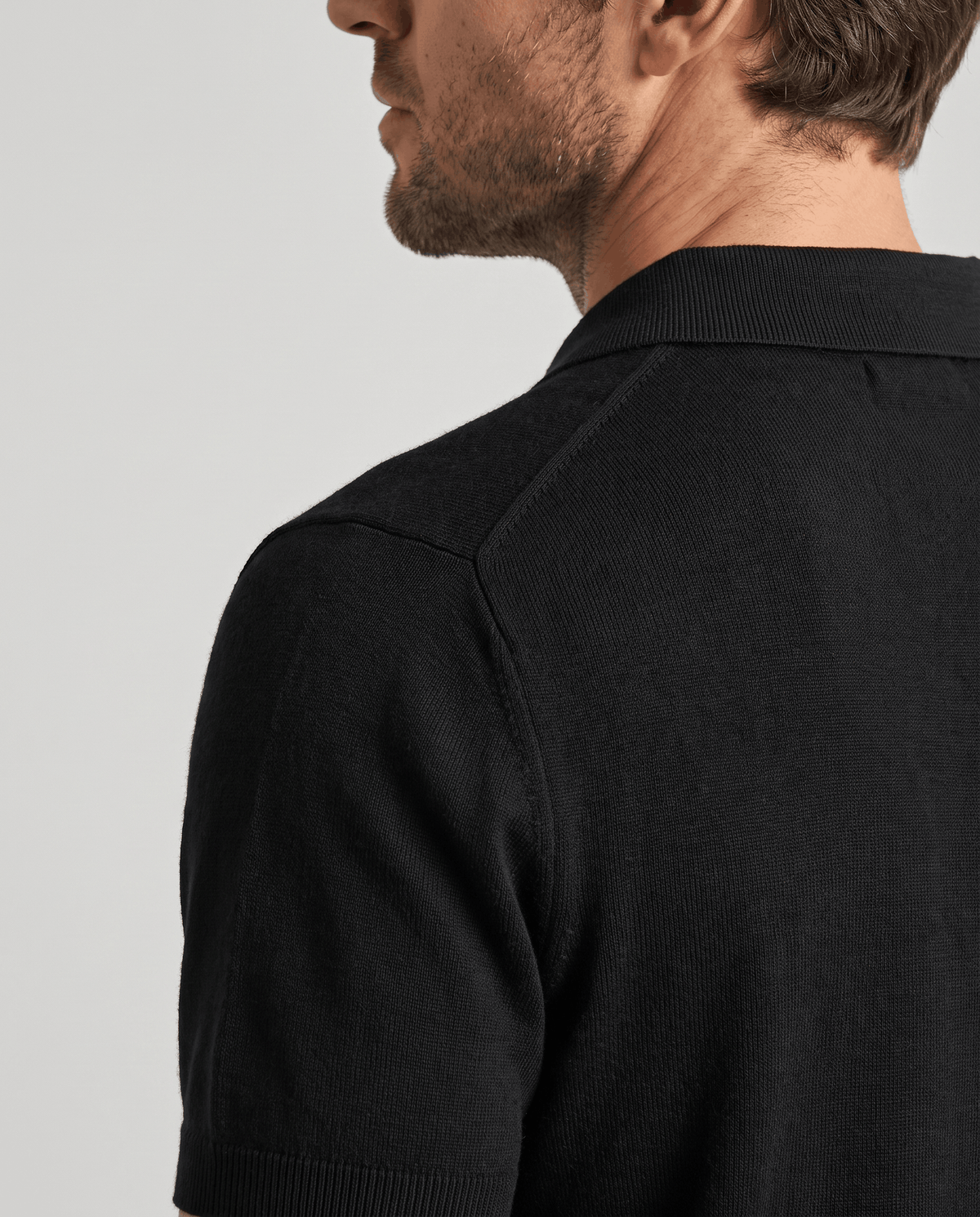 Side view of the collar and shoulder on the Elias black wool knit polo sweater