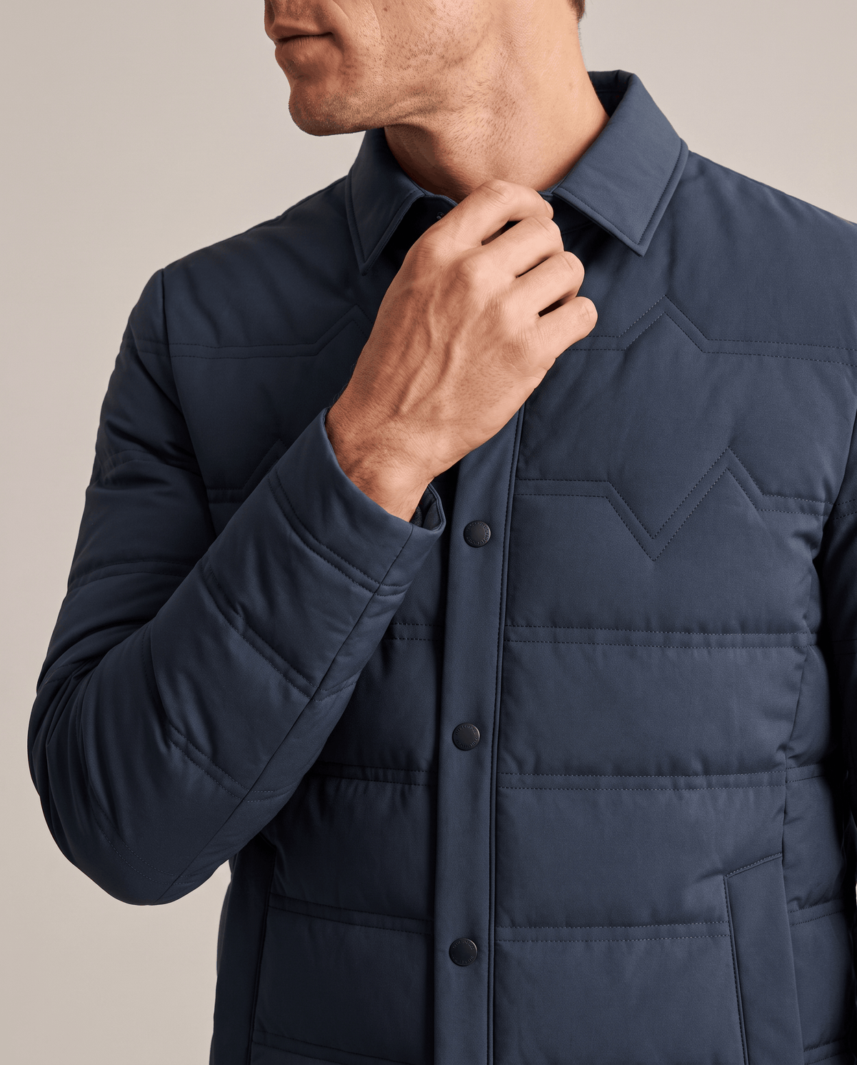 Close-up of the point collar and snap placket on a blue puffer jacket