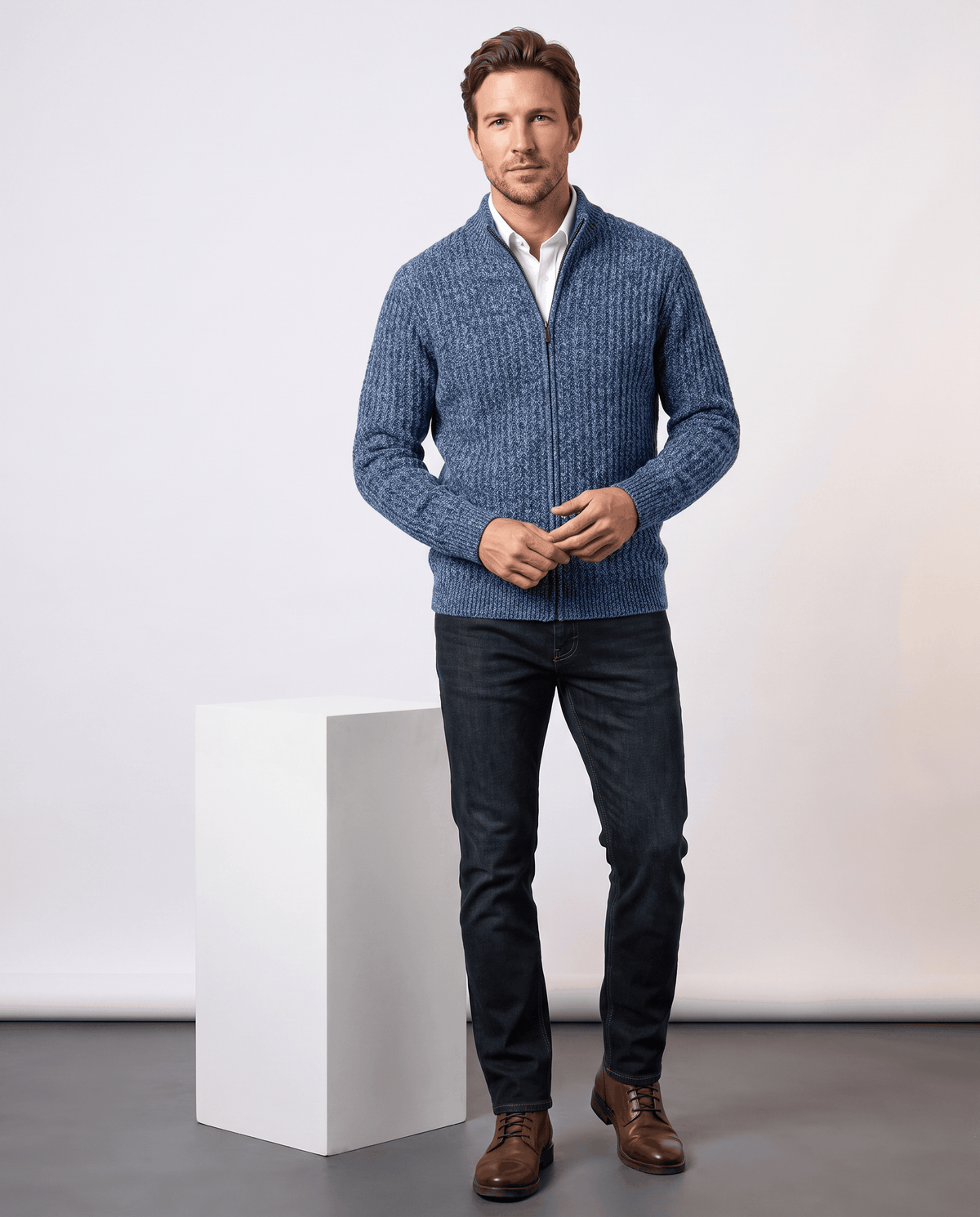Full-length view of a man wearing the Julian blue cardigan with dark jeans