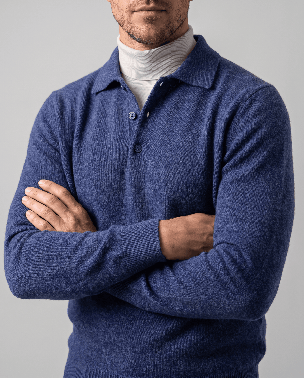 Man with arms crossed wearing the Elias blue wool knit polo sweater over a turtleneck